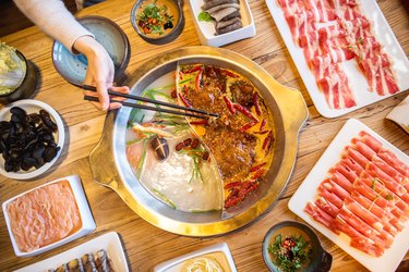 Double flavor hot pot on the table. Eating hot pot at restaurant.