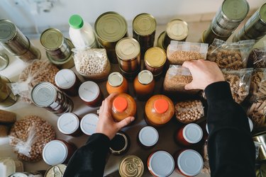 Woman is rearranging the nonperishable food at the food bank