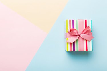 present wrapped with pink bow on pastel background