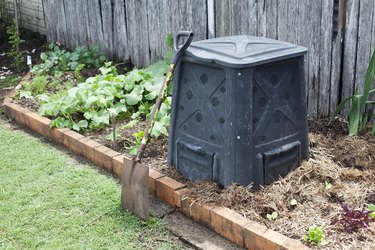 Compost bin in a backyard vegetable garden.