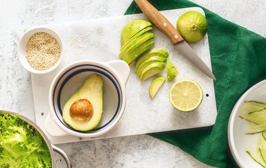 Healthy ingredients for green avocado salad on white background