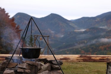 Cooking food on campfire in mountains. Camping season