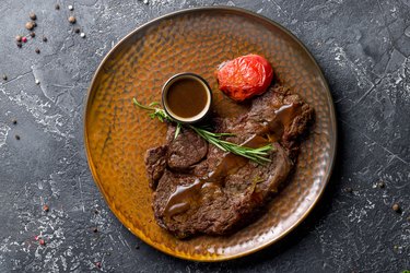 juicy Ribeye steak on brown plate with pepper sauce top view