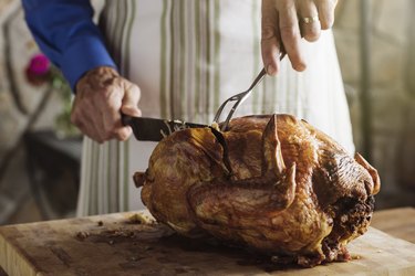 Man carving fresh roasted turkey at home