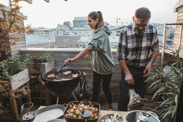 Barbecue on a small wooden outdoor balcony.