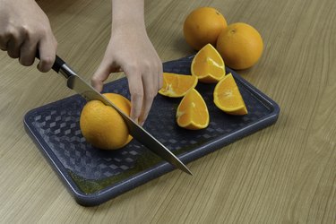 Cut orange on a plastic board.