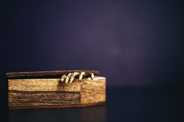 Halloween background with coffin opening showing skeletal hand