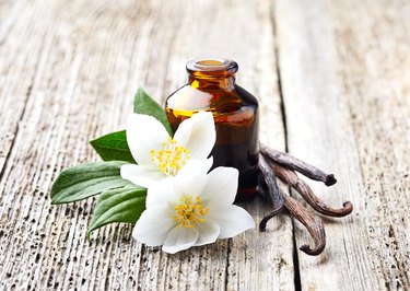 Jasmine and vanilla essential oil on wooden background