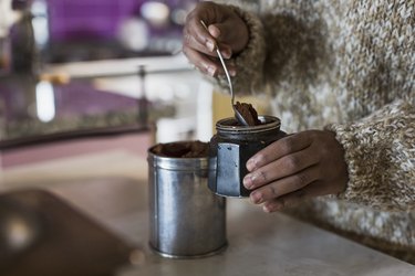 Young woman in kitchen preparing coffee