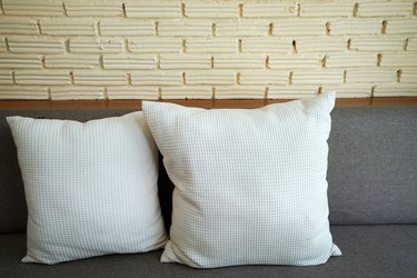 Cotton pillows on cushion sofa couch with white brick wall on the back