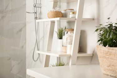 Shelving unit with toiletries in bathroom interior