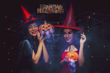 Vampire girls holding pumkin with darkness background