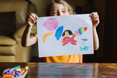 Little girl showing her drawing