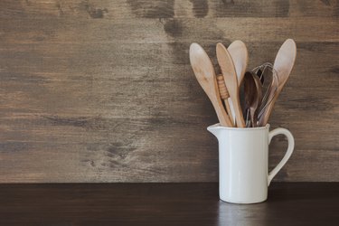 Crockery, clayware, dark utensils and other different stuff on wooden tabletop. Kitchen still life as background for design. Copy space.