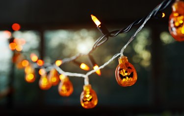 Pumpkin electric light string against the window. Halloween theme