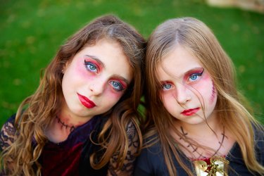 Halloween makeup kid girls blue eyes in outdoor lawn