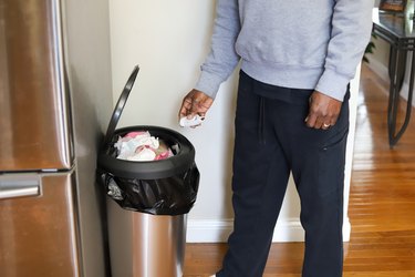 African-American Man Throwing Trash In The Trash Can