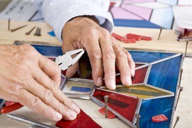 Stained glass craftsman working on project