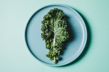 Overhead view of kale on a plate against green background