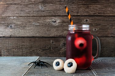 Halloween eyeball fruit punch in a mason jar against dark wood