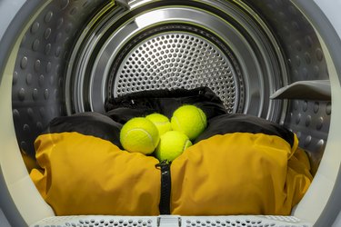 Multiple tennis balls with clothes in tumble dryer drum to  ensure that down is loosened and feathers do not stick together, fluff up laundry, pillows, sheets