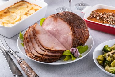 Honey glazed spiral sliced ham with side dishes for a celebration dinner