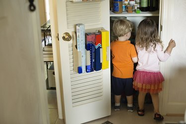 Male and female toddler friends searching pantry