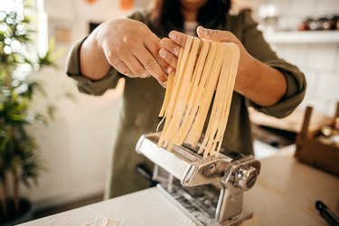 Woman making linguine with a pasta maker