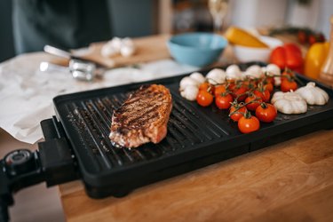 Close-up of steak and vegetables cooking on barbecue grill