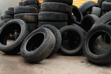 Old worn-out car tires from cars and trucks are piled up. The concept of environmental protection, acceptance for secondary use.
