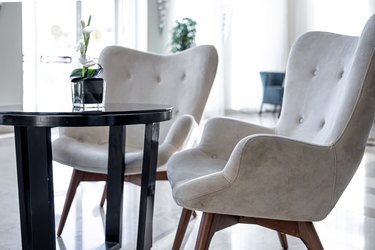 Comfortable white chairs near the table with a bouquet of flowers.