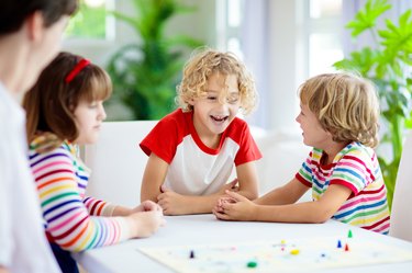 Family playing board game. Kids play.