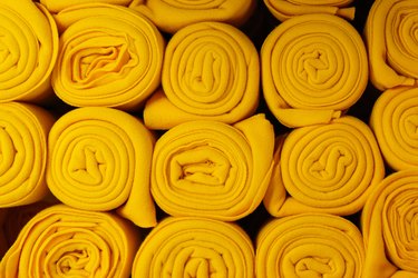 Twisted yellow blankets in a roll as background, home