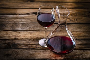 Wine decanter and wineglass on rustic wooden table. Copy space