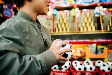 Young Boy Holding Soft Ball At Fun Fair Stall