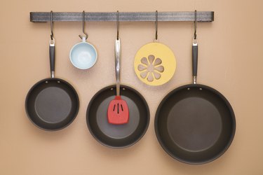 Pans and utensils hanging on kitchen wall