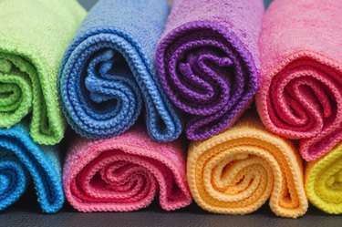 Colorful rolled up microfibre cleaning cloths arranged in a rows
