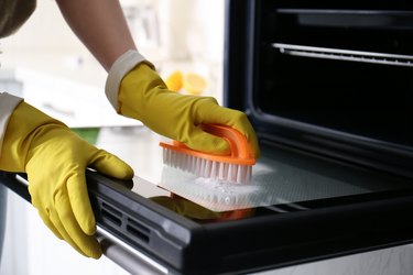 Woman cleaning oven door