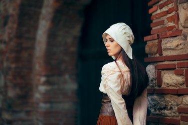 Medieval Woman in Historical Costume Wearing Corset Dress and Bonnet