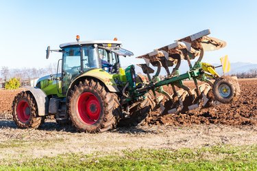 Tractor plowing a field.Not John Deere but Claas tractor