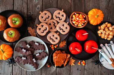 Rustic Halloween treat table scene, top view over a dark wood background