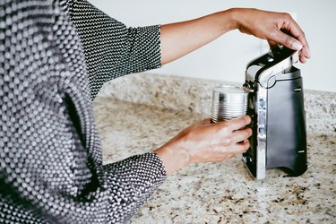 Woman Uses Electronic Can Opener to Open Can of Food