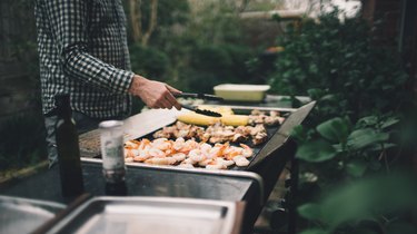 Grilling shrimp, meat and vegetables on barbecue