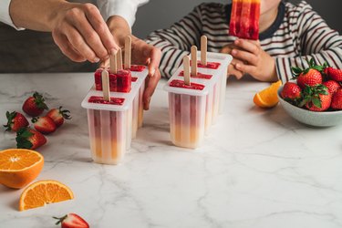 Mother making ice pops for her son with posicle molds