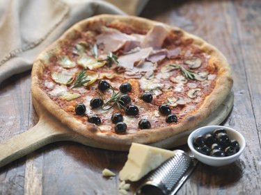 Homemade quattro stagioni pizza with ham, artichokes, olives, mushrooms and mozzarella cheese