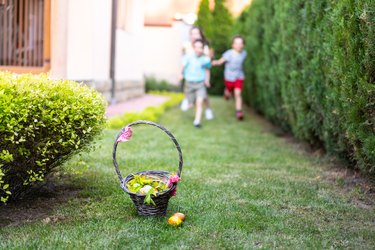 Children running towards a basket of Easter Eggs