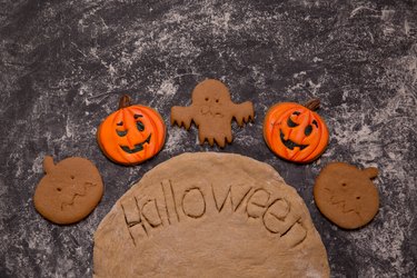 Halloween, pumpkin shaped cookies, dough on the table.
