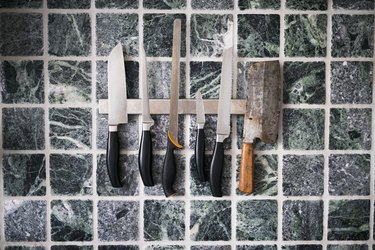 Kitchen knives against tiled wall