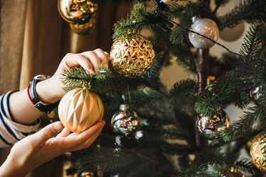 closeup of woman hand decorating Christmas tree