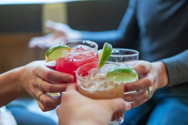 Friends toasting with margaritas and tropical drinks